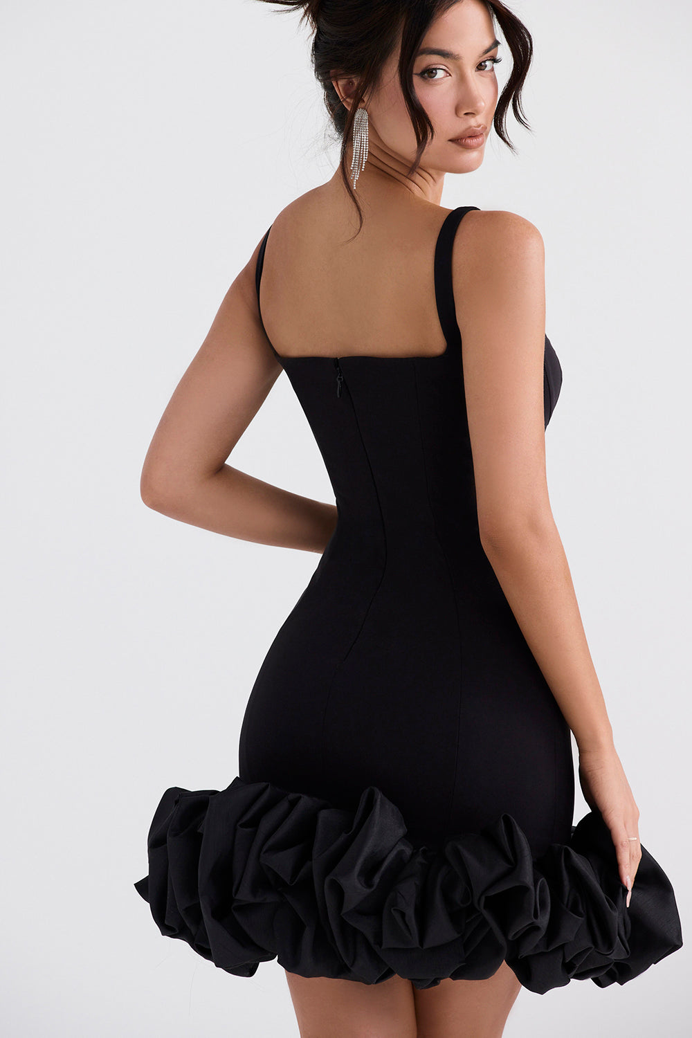 Un elegante vestido negro con hermosos volantes en el dobladillo