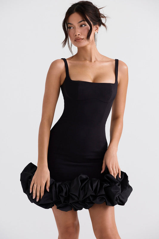 Un elegante vestido negro con hermosos volantes en el dobladillo